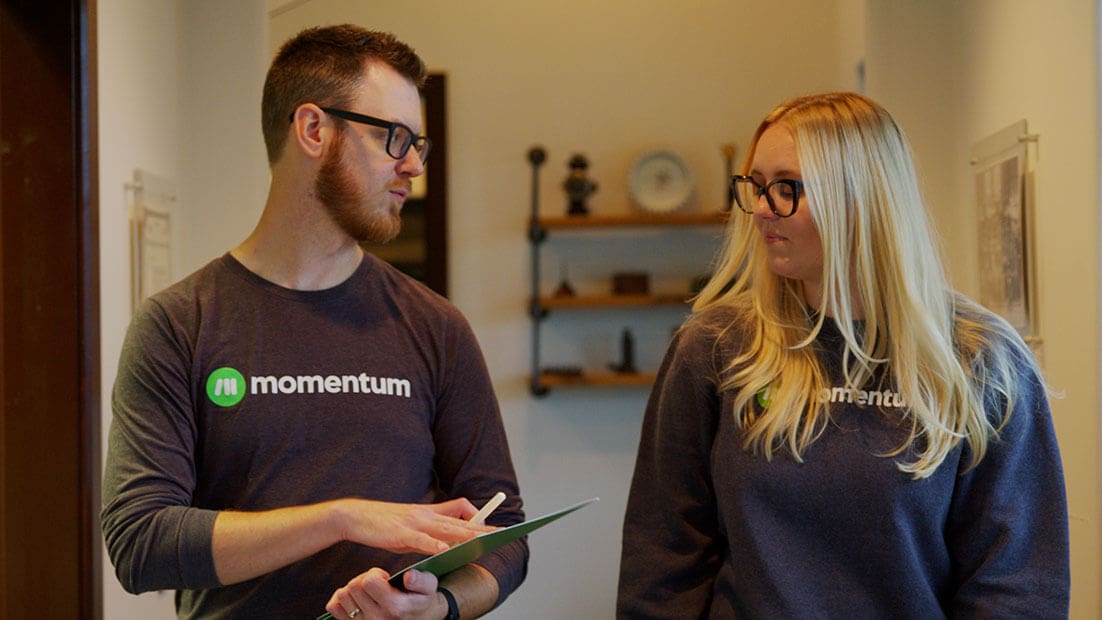 Two Momentum team members walking down office hallway