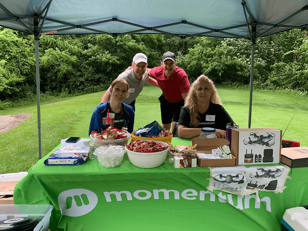 Momentum team and golfers at the Momentum booth at the AIAM golf outing