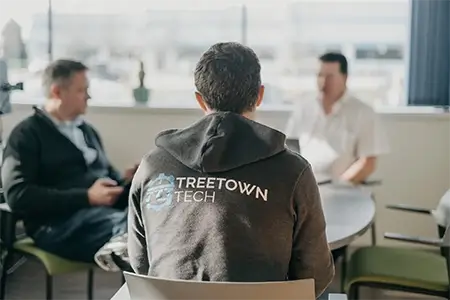 A group of Treetown Tech employees meeting to discuss a project.